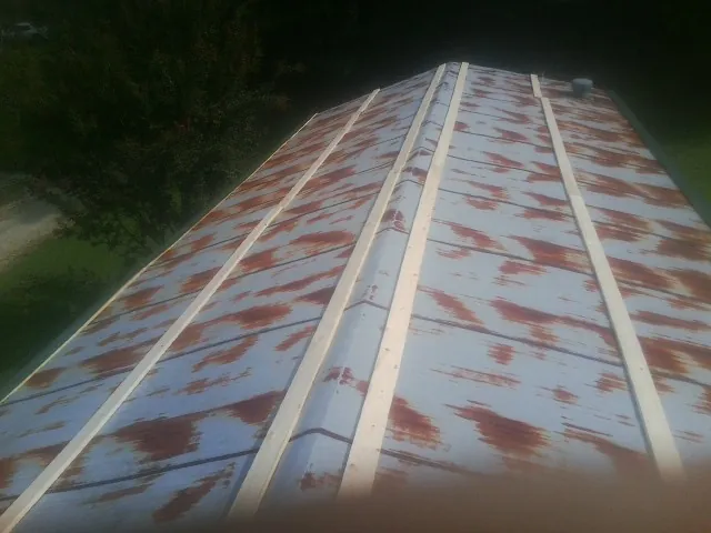 Rusted metal roof panels with new wood purlins before replacement — Storm Damage Roof Repair in Meredith by Roofing Brothers