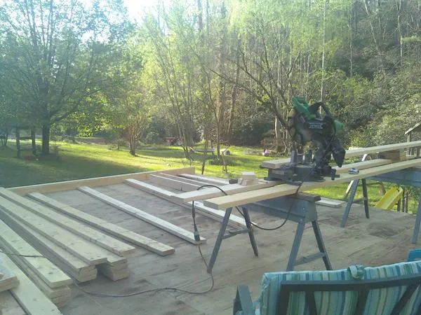 Miter saw and framing lumber on a deck under construction in Meredith