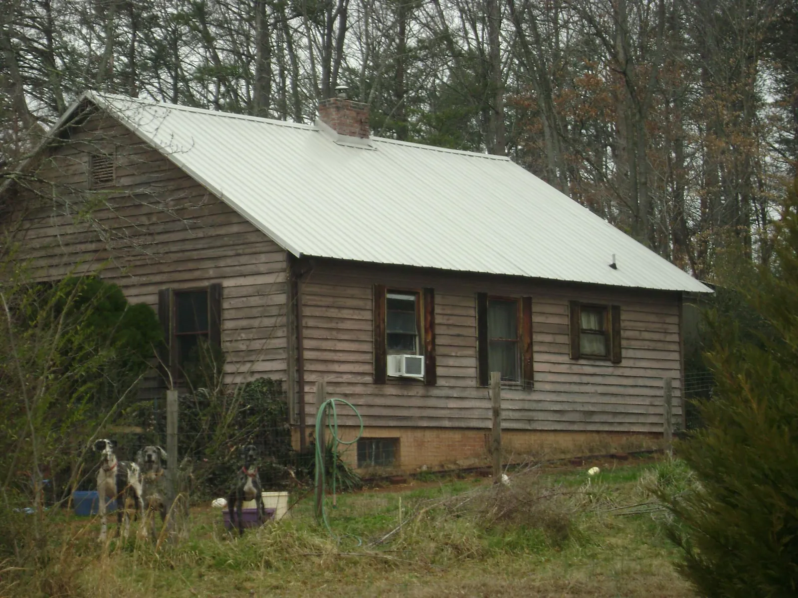 White metal roof on an old wood sided farmhouse, from a Metal Roof Installation job in Meredith